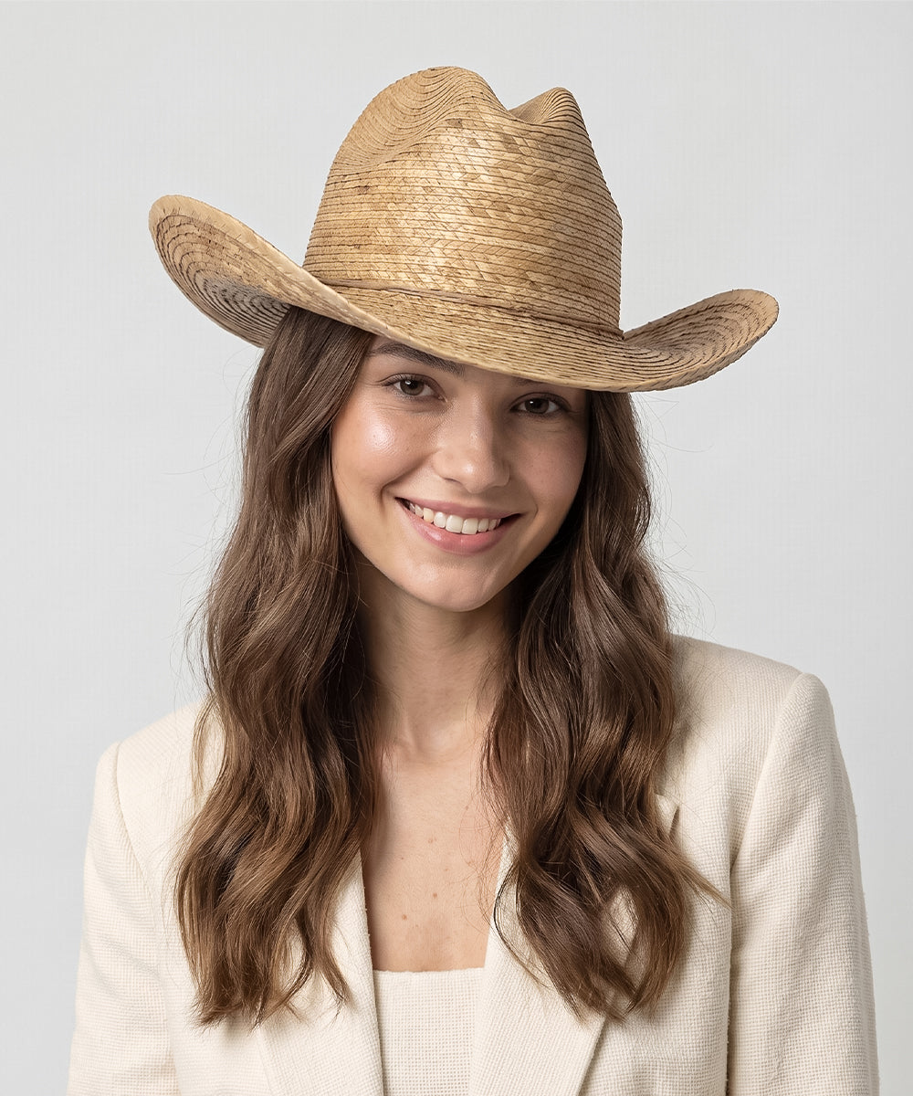 Women's bohemian western fashion trend pairing a dark brown straw cowboy hat with denim