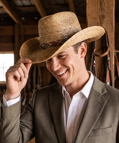 Men's outdoor adventure clothing inspiration highlighted by an earthy brown structured straw hat