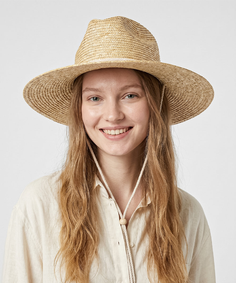 Women's resort minimalism fashion lookbook styled with an organic cream straw hat
